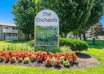 a picture of the orchards sign with flowers in front of it
