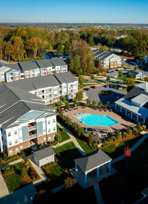 an aerial view of a resort with a pool and buildings