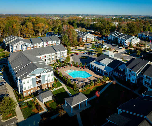 an aerial view of a resort with a pool and buildings