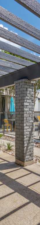 Outdoor covered seating and grilling area at The Melville Apartments