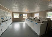 Thumbnail 12 of 24 - A laundromat with washers and dryers lined up.