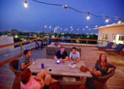Thumbnail 8 of 10 - Four people sitting around a table on a rooftop. at The Mobile Lofts, Alabama, 36604