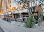 Thumbnail 2 of 8 - A building with a sign that says "For Guest Use, Visit" is located on a street with trees and other buildings in the background.