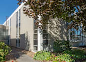 Thumbnail 4 of 7 - A modern building with a garden in front.