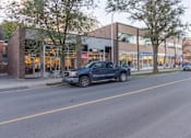 Thumbnail 4 of 6 - A dark blue pickup truck is parked on the side of a street.