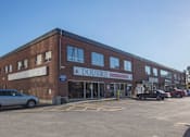 Thumbnail 5 of 6 - A brick building with a sign that says "DOUVRIS" on it.