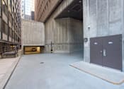 Thumbnail 4 of 7 - A large, empty parking garage with concrete walls and floors.