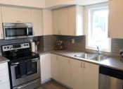 Thumbnail 5 of 7 - Kitchen with Stainless Steel Appliances and White Cabinets