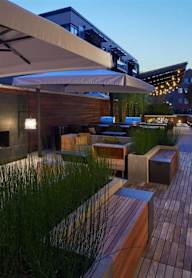 A modern outdoor seating area with a fireplace and a large umbrella.at Ten Select Apartments, Arlington, Virginia