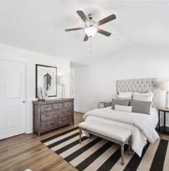 a bedroom with a bed and a ceiling fan