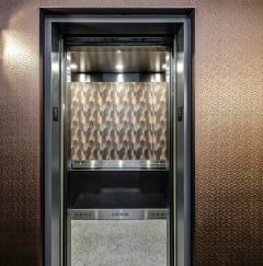 a metal elevator door with a glass window