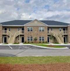 an apartment building with stairs and a parking lot  at The Meadows, Bloomingdale, Georgia