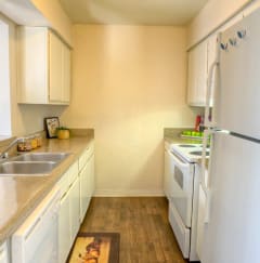 a kitchen with white appliances and white cabinets at Auburn Glen Apartments, Florida, 32256
