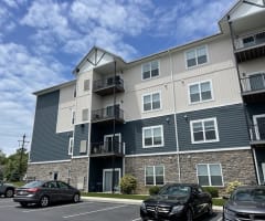an apartment building with cars parked in front of it
