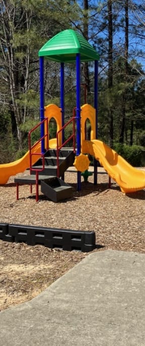 a playground with slides and a bench in a park