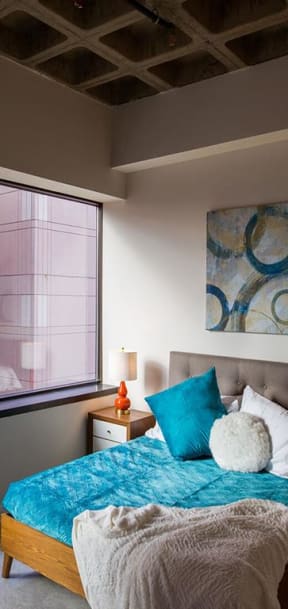 a bedroom with a bed and a large window