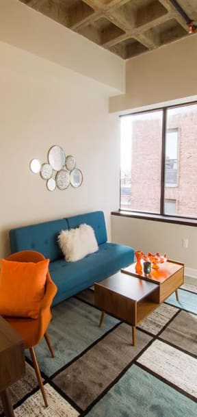 a living room with a blue couch and a large window