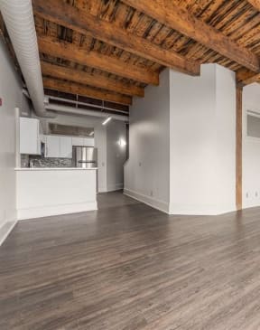 an empty living room with wood floors and white walls at East 4th Street, Cleveland