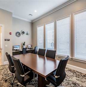 a conference room with a desk and chairs and a mirror