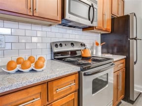 a kitchen with a stove and a counter with oranges on it