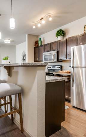 A modern kitchen with a bar stool in front of the counter.