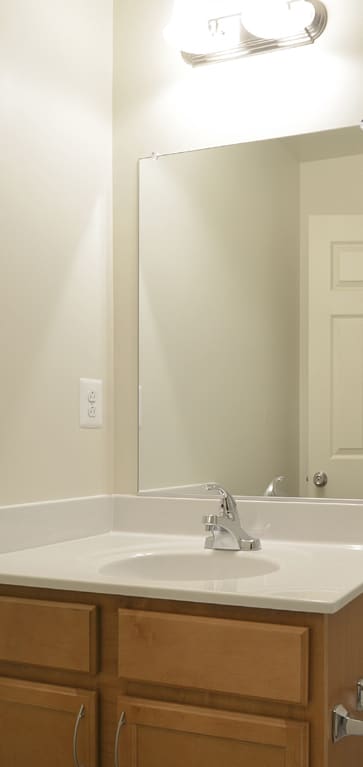 a bathroom with a toilet sink and mirror and a shower at The Pointe at Manorgreen Townhomes, Maryland, 21220