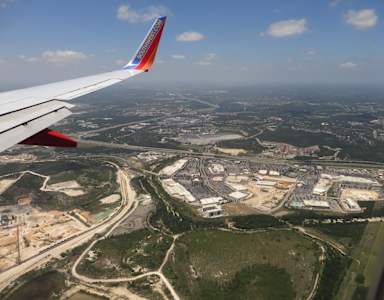 A view from an airplane window of a runway and surrounding area.