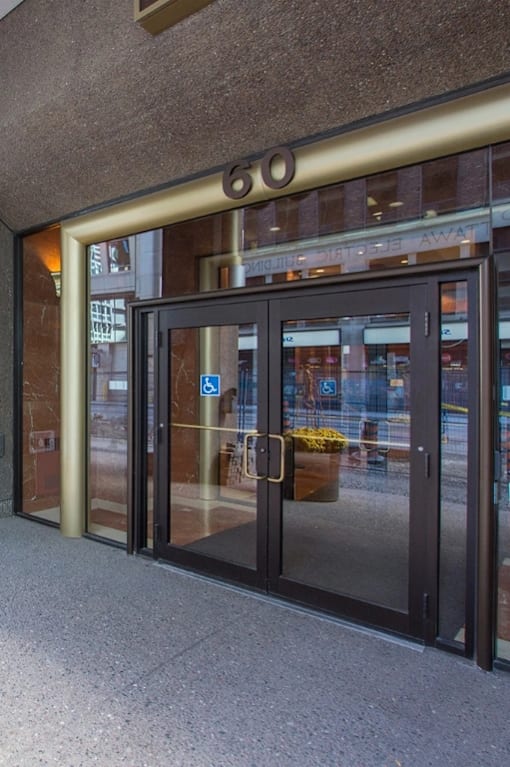 A long hallway with a flower pot on the left and a door on the right.