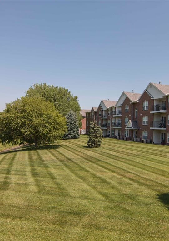 a large green lawn in front of an apartment building