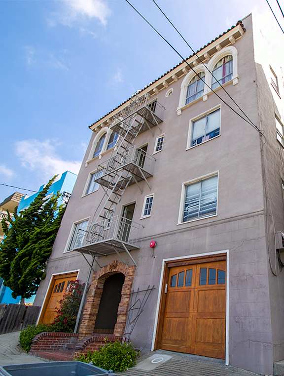 A building with a brown door and a fire escape.