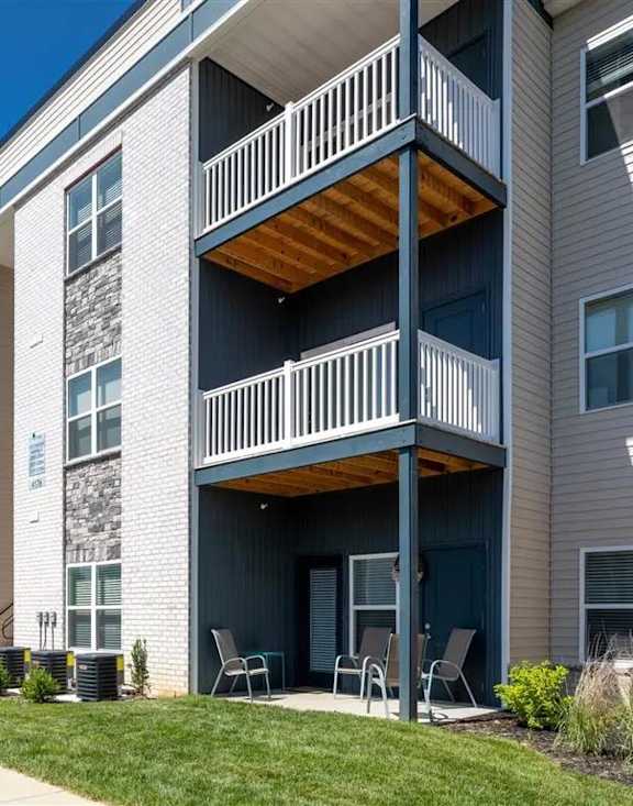 A modern apartment building with a parking lot in front.