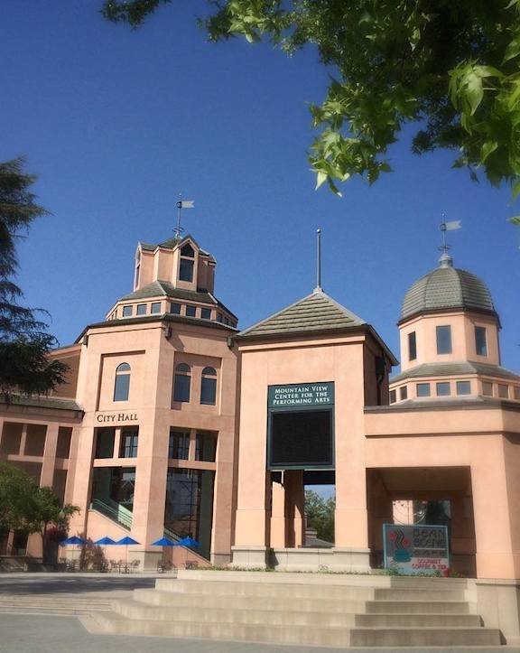 A pink building with a sign that says City Hall.