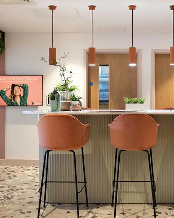 a kitchen with a counter and three stools