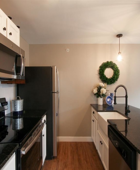 a kitchen with black counter tops and stainless steel appliances