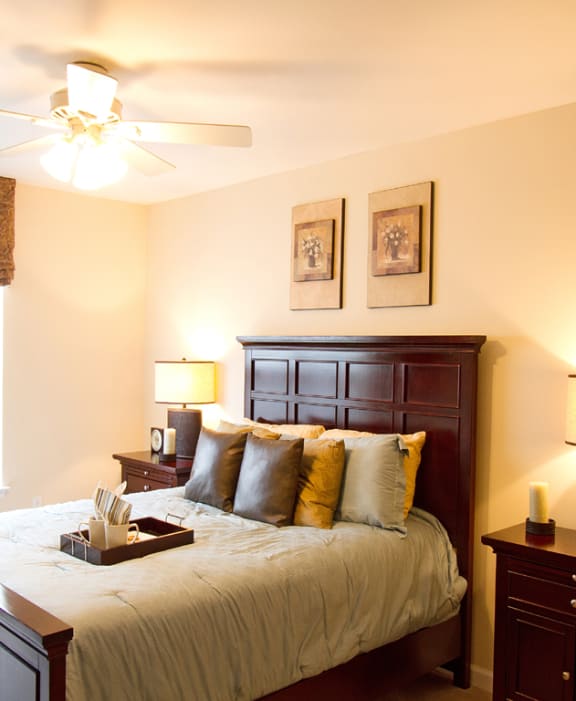 a bedroom with a large bed and a ceiling fan at The Summit at Owings Mills Apartments, Owings Mills, MD 21117