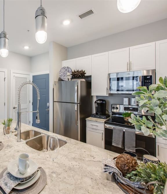 an open kitchen and dining room with stainless steel appliances at Westport Apartments, Virginia