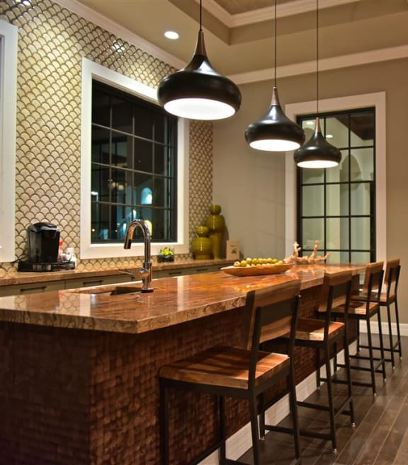 a kitchen with a long counter and chairs at The Atlantic at Tradition, Port St Lucie, FL, 34987