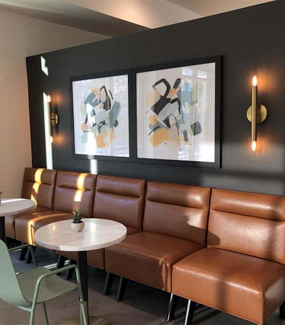 Stylish resident lounge at Morrow Apartments in St. Paul, MN, featuring modern leather cafe-style seating.