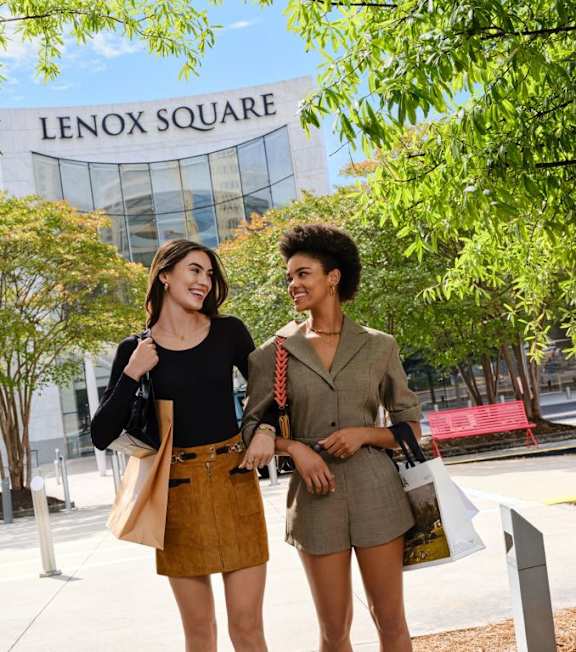 Two people standing in front of Lenox Square shopping center.