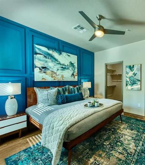 A bedroom with a bed, a rug, and a ceiling fan. at Craft at Gilbert and Baseline Apartments, Mesa