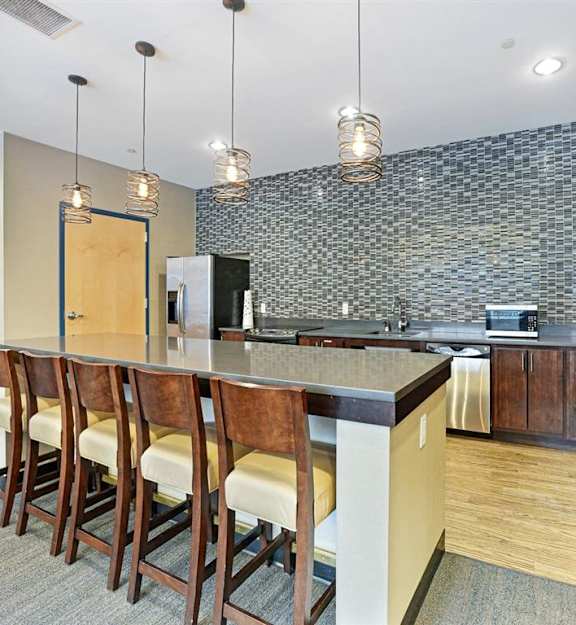A kitchen with a bar area and chairs.