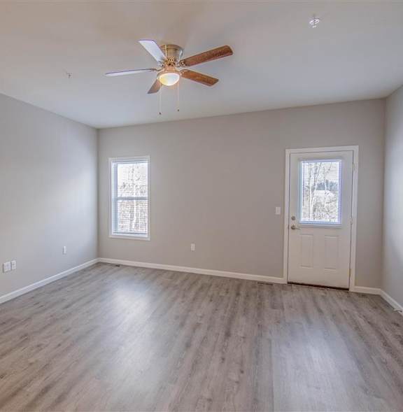 A room with a ceiling fan and a window.