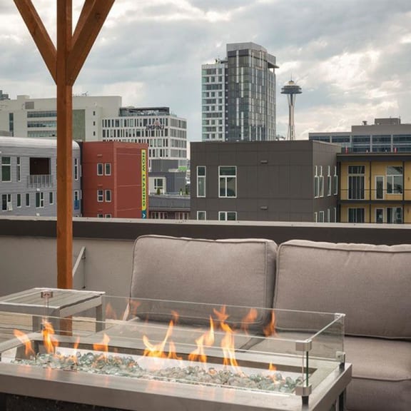 a fire pit on a patio with a view of the city