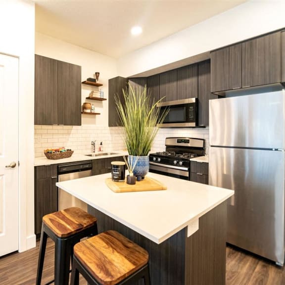a kitchen with a island and a stainless steel refrigerator