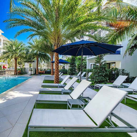 a pool with lounge chairs and an umbrella