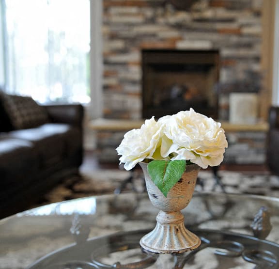 A vase with white flowers sits on a glass table at Shannon Manor Townhomes in Davison, MI