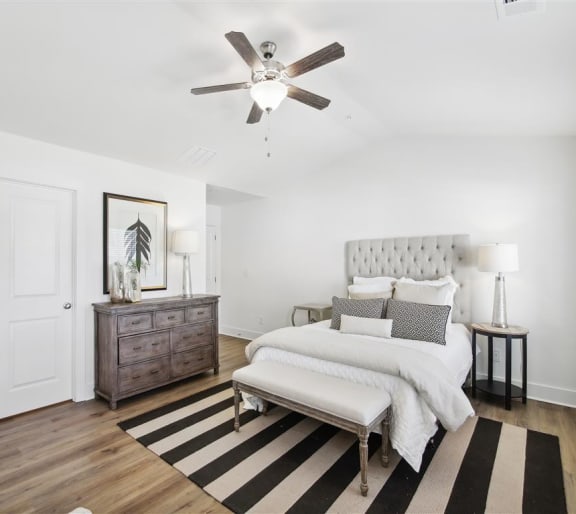a bedroom with a bed and a ceiling fan