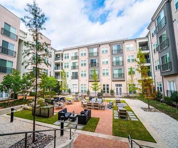 The courtyard with tables, chairs, and grilling stations at Parkside at Firewheel Apartments. 