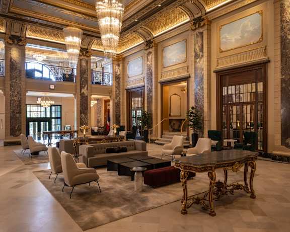 a large lobby with couches and chairs and a table  at the Belden Stratford in Chicago, IL