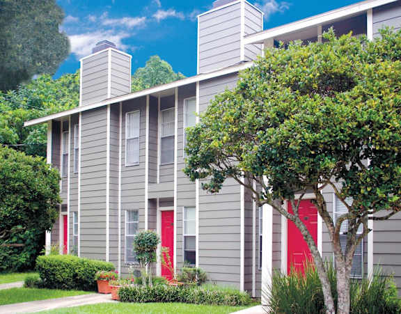 a gray apartment building with red doors